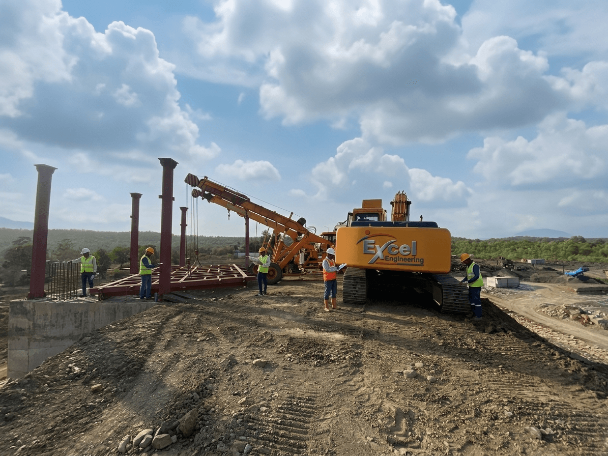 Excel Engineering excavator-crane erecting steel columns on hilltop